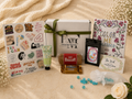 Collection of items including a box, cards, and small products on a textured surface.