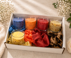 Set of colorful candles in a box with decorative ribbons on a light background
