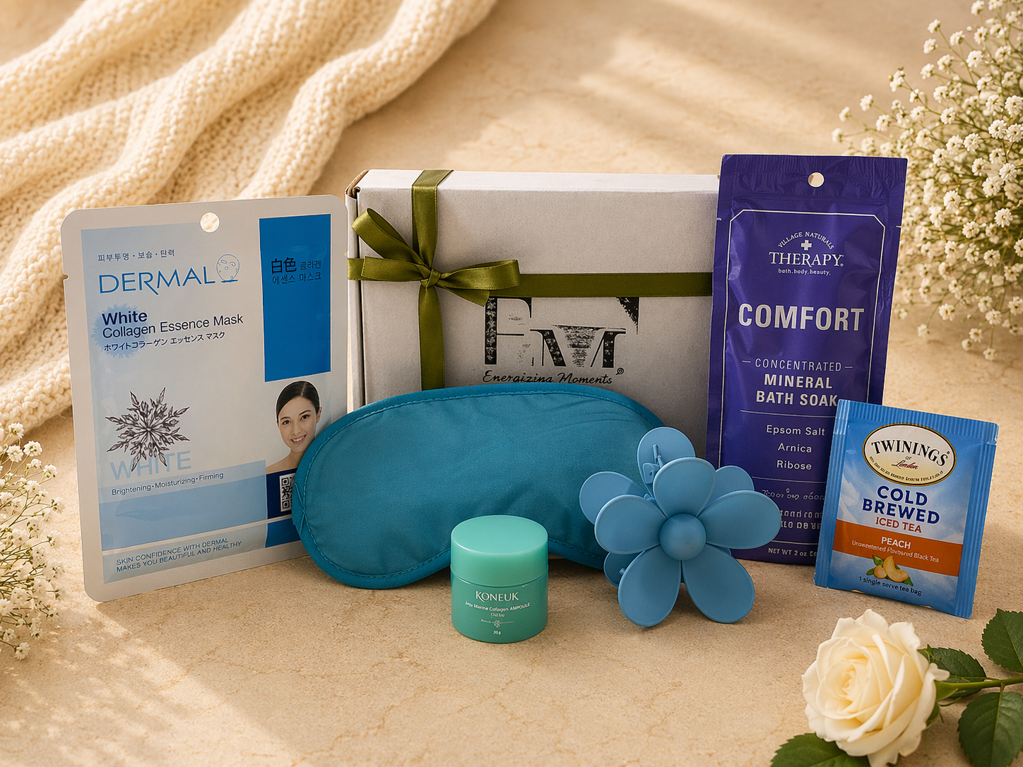 Collection of self-care items including a blue eye pillow, cream, and tea on a soft surface with flowers.