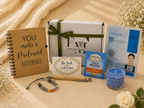 Gifting set with notebook, card, box, and other items on a textured surface.