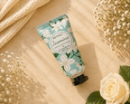Hand cream tube labeled 'Jasmine' by Besnel on a beige surface with flowers.