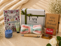 Gift set with 'Color Me Blessed' book, 'You Make a Profound Difference' notebook, candy, and other items on a textured surface.