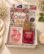 Gift box with 'Color Me Blesse' book, eye masks, and Twinings tea on a light background