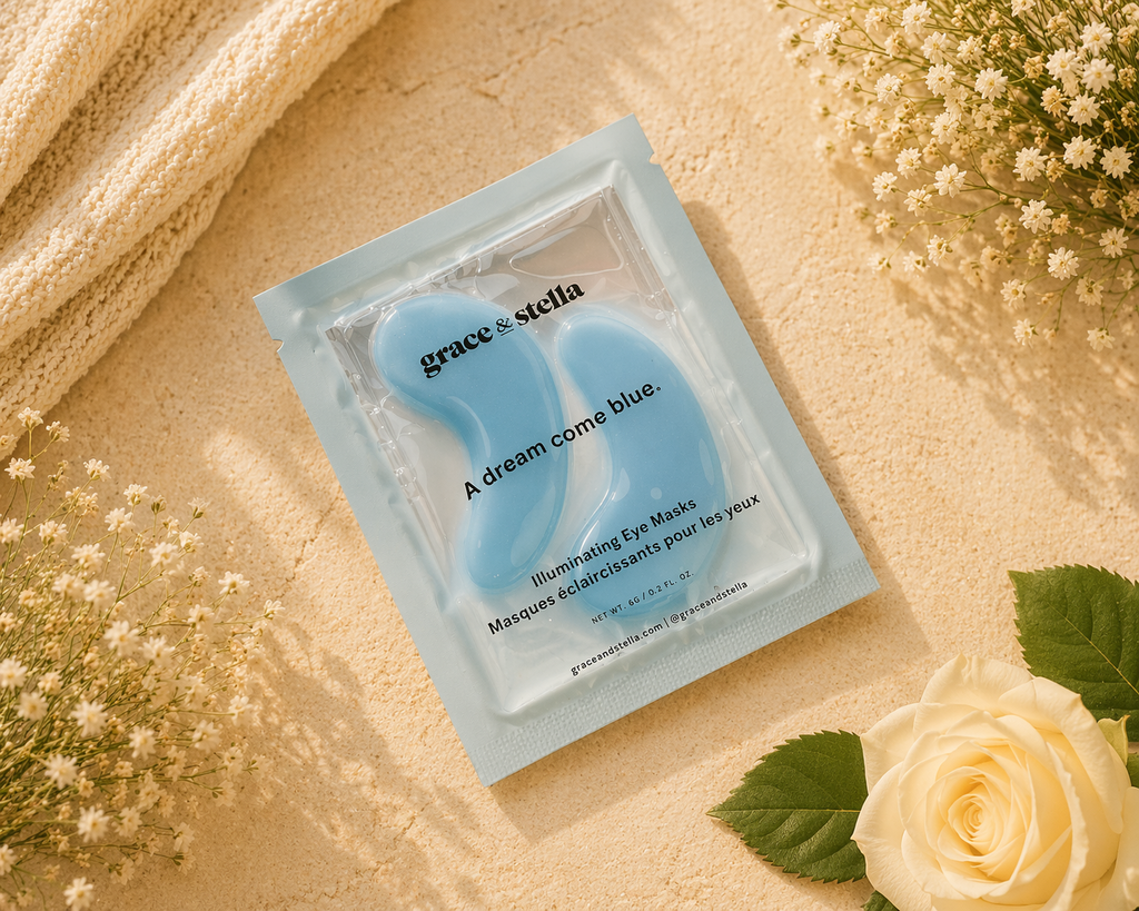 Blue eye mask in packaging with 'grace & stella' branding on a beige background with flowers.