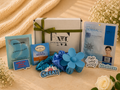 Collection of items including a box, flowers, and various products on a textured surface.